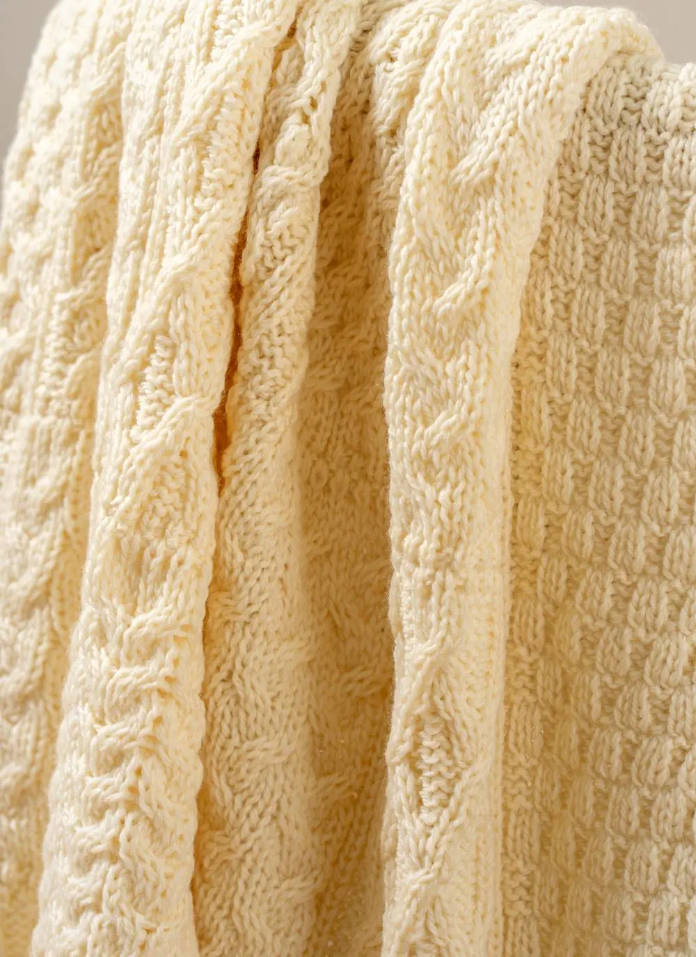 Close-up of cream Aran throw draped across chair